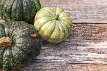 Autumnal Background. Natural autumn fall view pumpkins on wooden background. Inspirational october or september wallpaper. Change of seasons ripe organic food concept. Halloween party Thanksgiving day
