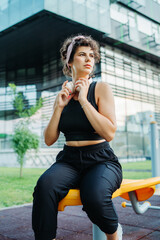 Young caucasian woman putting headphones preparing for training in park