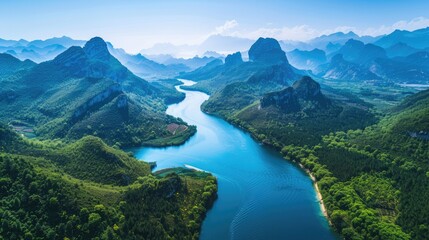 Aerial view of blue water river winding through mountains, surrounded by dense greenery and clear skies