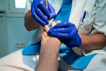 Unrecognizable podiatrist treating patient's foot