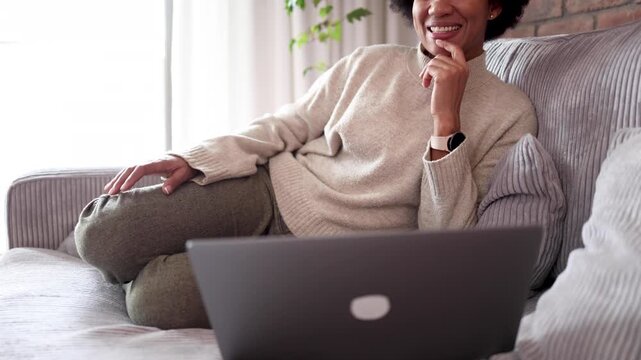 Happy African American woman watching something on her lapt