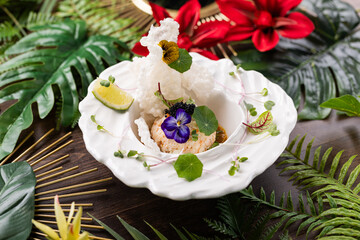 Gourmet Seafood Tartare with Edible Flowers, Lime, and Rice Crisp