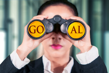 Female entrepreneur using binoculars with the text GOAL on it