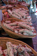 Variety of homemade dried salami sausages in French butchery shop, Dordogne, France, meat food background close up