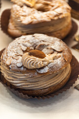Freshly baked stuffed sweet Paris-Brest pastries in traditinal French bakery in small village in Provence