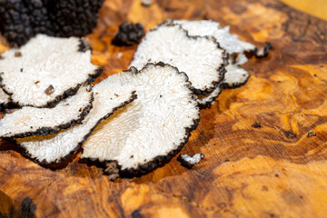 Slices of Italian black summer truffle, tasty aromatic mushroom, close up