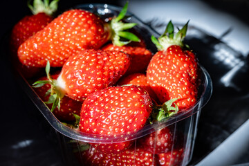 Plate with french organic red ripe sweet strawberries Fraises de Plougastel, harvested in France