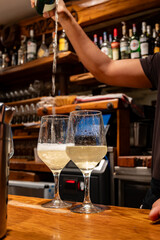 Pouring of txakoli or chacolí slightly sparkling very dry white wine produced in Spanish Basque Country in typical pinchos bar in old part of San Sebastian or Donostia, Spain
