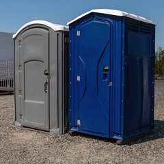 Two porta potty toilets outside near raceway.