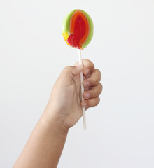 Lollipop in hand child on white