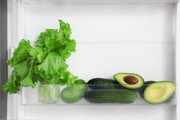 Fresh green vegetables in fridge in kitchen. Closeup