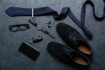 Set of male accessories with shoes, wrist watch and tie on black background. Top view