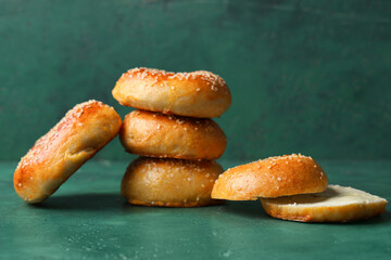 Tasty bagels with sesame seeds on green background