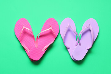 Hearts made of different flip-flops on green background
