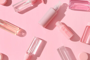 Composition with different travel cosmetic products on pink background