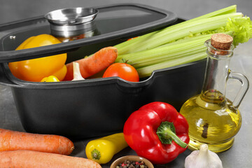 Black pot and fresh products on grey table