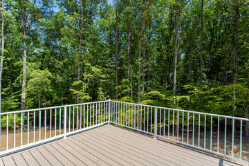 Fototapeta premium Beautiful Open Deck With White Railings Providing A View Of Wooded Surroundings