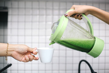 Hand Receiving Green Smoothie Juice Drink From Blender