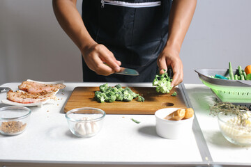 Close Up Hands Holding Knife While Slicing Broccoli On Cutting Board Preparation For Cooking Chicken Steak
