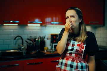 Woman Unhappy with the Smell in her Kitchen at Home. Stressed housewife feeling disgusted with the...