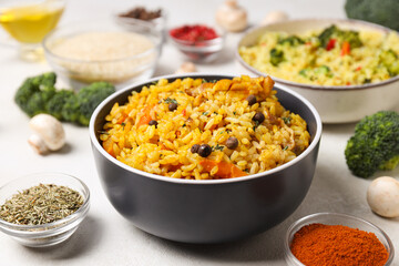 Pilaf in bowls, rice, spice and vegetables on white background, close up