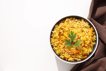 Pilaf in bowl and towel on white background, space for text