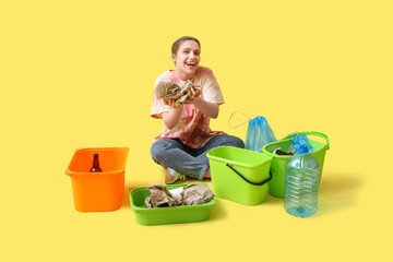 Naklejka premium Young woman sorting trash on yellow background