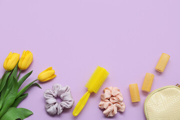 Cosmetic bag with curlers, hair comb, silk scrunchies and tulip flowers on purple background