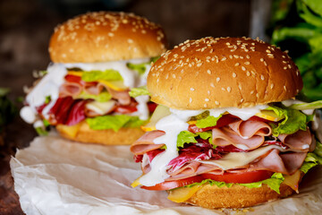 Burgers with ham tomato cheese, lettuce and ranch dressing