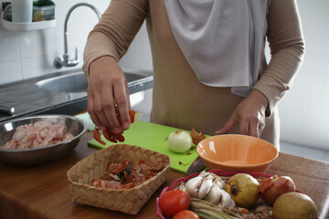 Asian muslim woman peeling onion