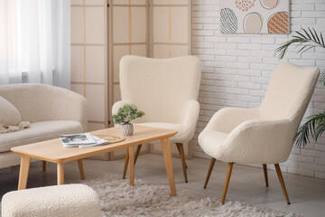 Cozy sofa, armchairs and coffee table in interior of living room