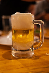 Glass of fresh beer with foam on table dinner. Close up