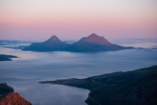 Midnight sun sunset view over Tomma island, in the archipelagio of Northern Norway, Helgeland. Smaltind, Breitind and Tortenviktind in the foreground.