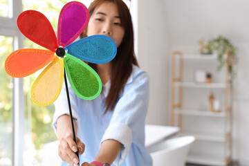 Young woman with toy windmill at home, closeup