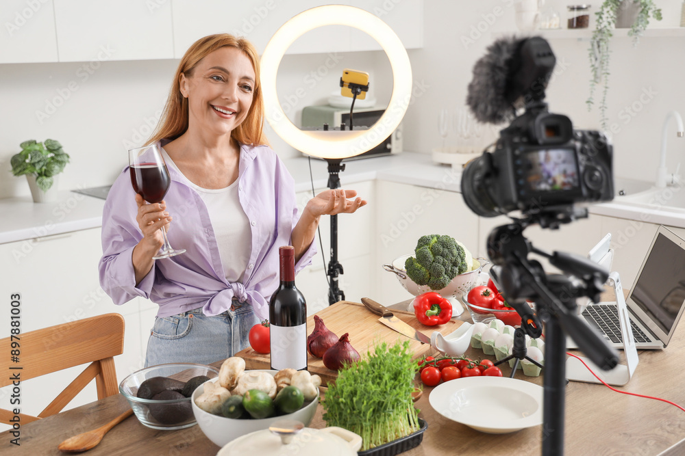 Canvas Prints Mature woman with glass of wine recording cooking video class in kitchen