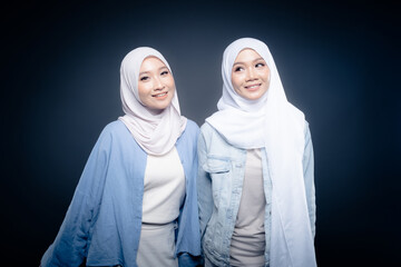 Portrait of a beautiful Malaysian and Indonesian Muslim young women wearing modern and casual wear with hijab on isolated studio background. Modern hijab fashion and beauty concept