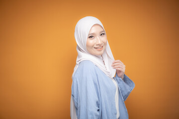 Portrait of a beautiful Malaysian and Indonesian Muslim young women wearing modern and casual wear with hijab on isolated studio background. Modern hijab fashion and beauty concept