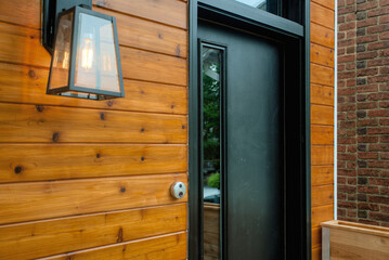 Modern Black Door With Wooden Siding And Outdoor Lantern Light Fixture