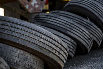 Used semi trucks and trailers tires stacked in a row near an old semi trailer