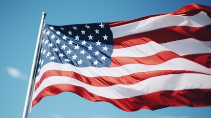 Close-up of a waving American flag under clear blue sky