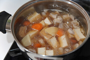 鶏もも肉と筍と厚揚げの煮物を作る様子