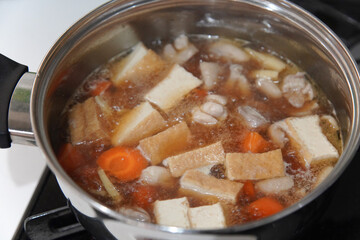 鶏もも肉と筍と厚揚げの煮物を作る様子