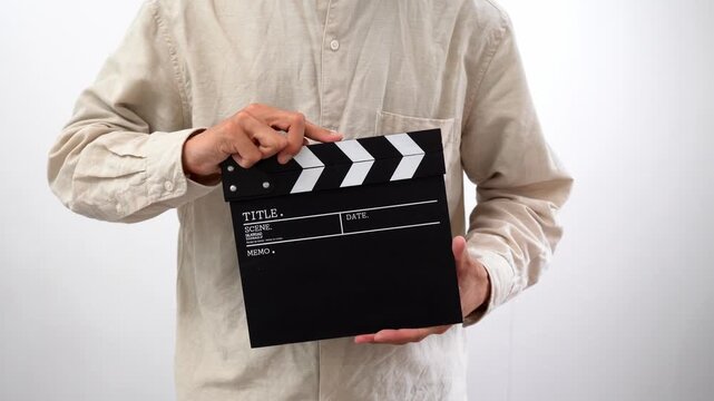 カチンコを鳴らす男性のバストアップ