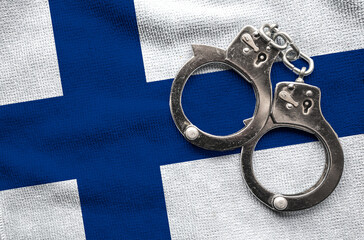 Flag of Finland and police handcuffs. Crime and offenses in country Concept
