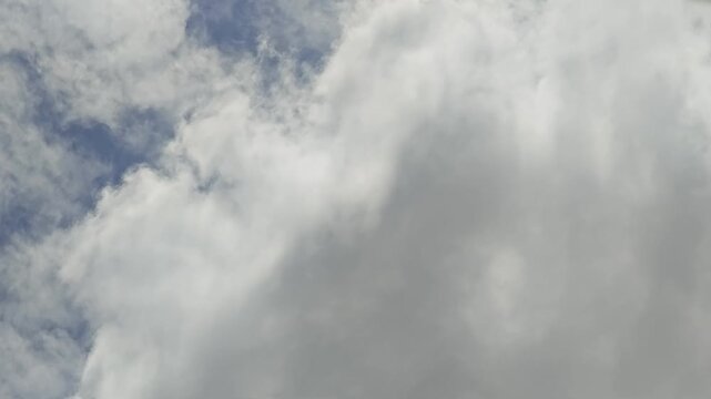 clear sunny blue sky with running fast huge white clouds by strong wind
