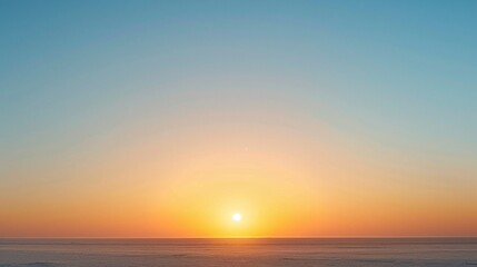 A minimalist sunrise, with the sun just peeking over a low horizon line in a clear sky