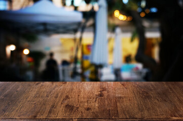 Empty dark wooden table in front of abstract blurred boken bankground of restaurant. Can used for display or montage your products. Mock up for space.