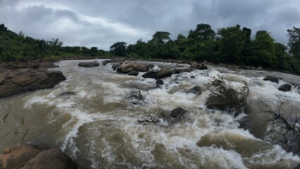 A serene stream flows over smooth rocks, creating a soothing sound of water cascading gently through the landscape.