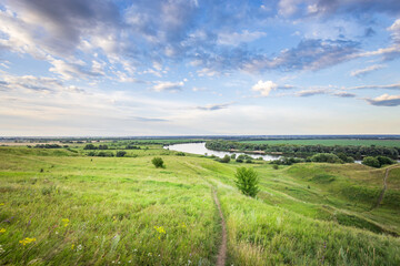Fototapeta premium A beautiful, open field with a river running through it