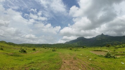 Obraz premium Peaceful plains surrounded by lush greenery and hills